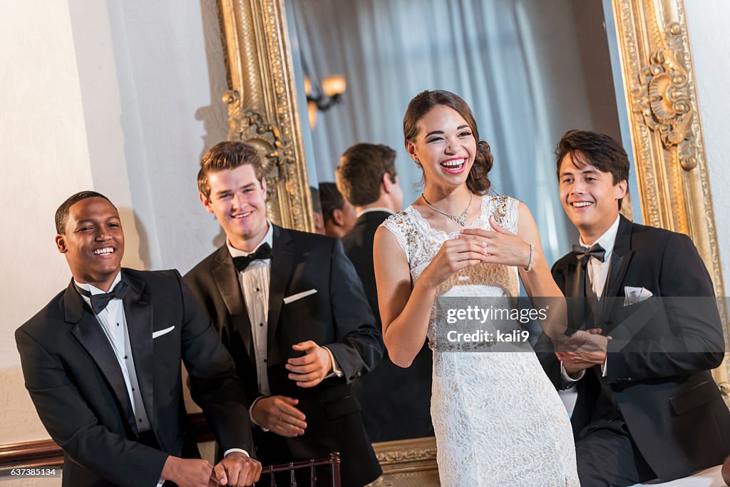 Young woman in gown with three men in tuxedos