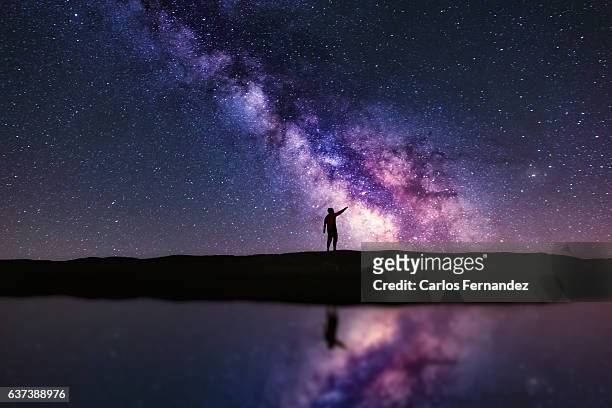 pointing the milky way - young man scientist stock pictures, royalty-free photos & images
