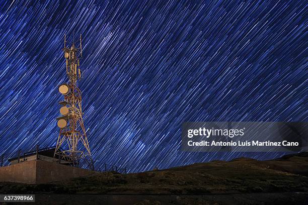 communication tower with star trail. - microwave tower stock pictures, royalty-free photos & images
