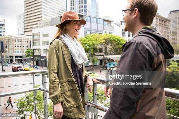 a man and woman smiling in the city. - seattle city life stock pictures, royalty-free photos & images