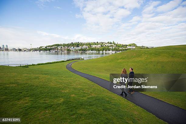 a couple walking a path - seattle city life stock pictures, royalty-free photos & images