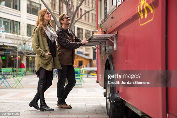 a couple at a food truck. - leather pants stockfoto's en -beelden