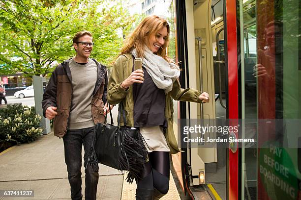 a man and woman using the street car. - sac à main blanc photos et images de collection