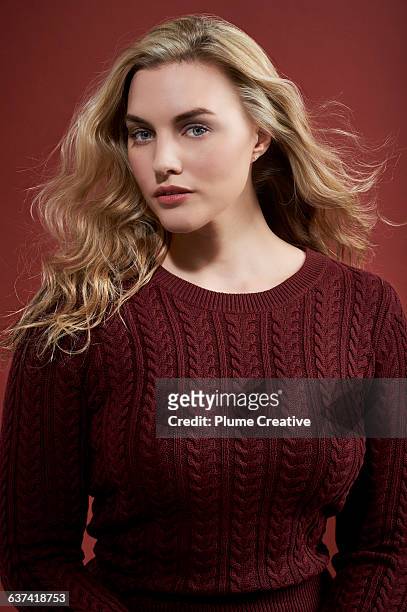 portrait of a confident woman in a red jumper - buxom blonde stock pictures, royalty-free photos & images
