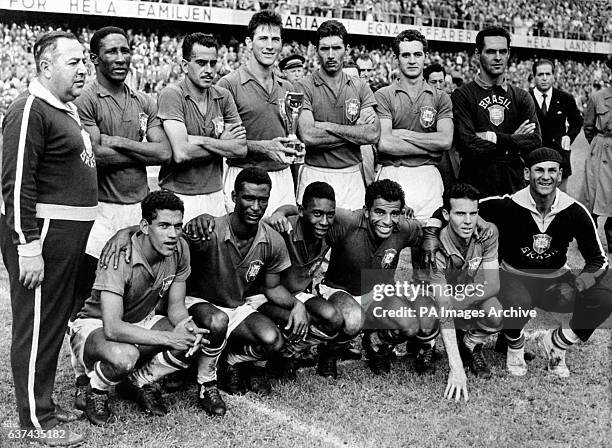 The victorious Brazil team with the trophy: Coach Vicente Feola, Djalma Santos, Zito, Bellini, Nilton Santos, Orlando, Gilmar Garrincha, Didi, Pele,...
