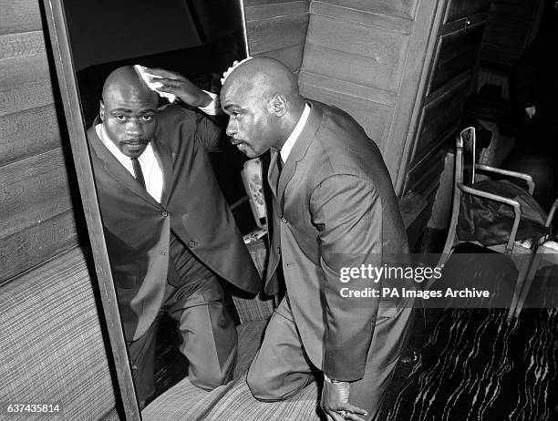 American middleweight Rubin Carter, in London for his bout with Harry Scott on March 9th, polishes his smooth scalp after a visit to a barber