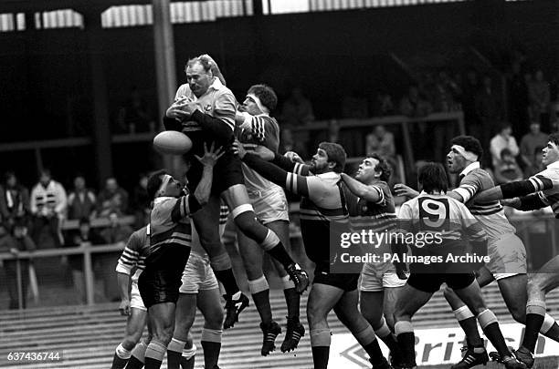 Overseas XV's Andy Haden drops the ball at a line out as he is assisted by teammates Enrique Rodriguez and Flippie Van Der Merwe