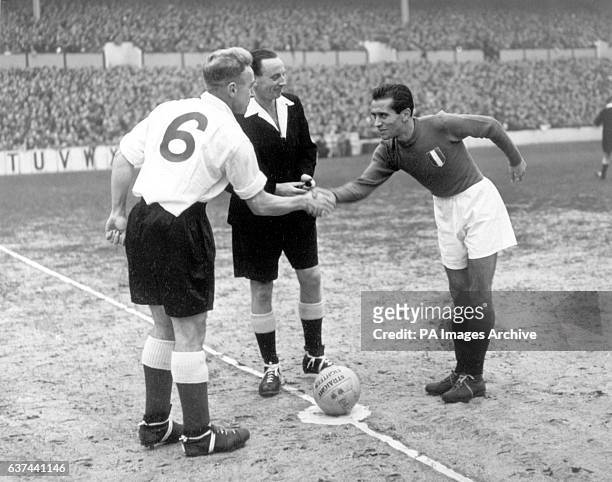 England captain Billy Wright shakes hands with Italy captain Riccardo Carapellese , watched by referee JA Mowat