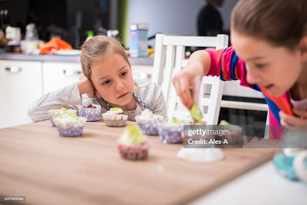 Girls decorating muffins