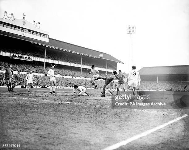 Tottenham Hotspur's Dave Mackay heads the ball away from the boot of Liverpool's Tony Hateley , watched by teammates Martin Chivers , Cyril Knowles ,...