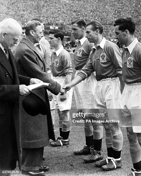 King George VI shakes hands with Blackpool's Stanley Matthews as Blackpool captain Harry Johnston introduces the king to his teammates before the...