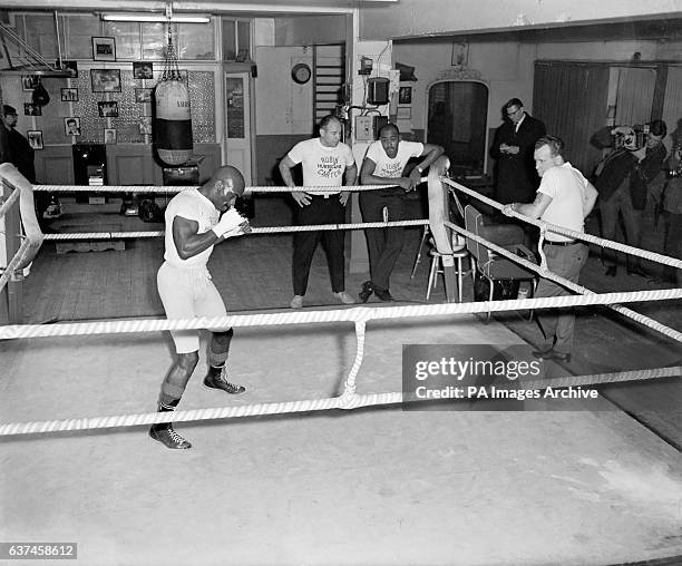 Rubin Carter working out in Joe Bloom's gym in preparation for his fight against Harry Scott at the Royal Albert Hall, watched by his manager Pat...