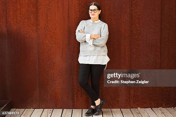 portrait of woman with crossed arms - older woman with brown hair foto e immagini stock