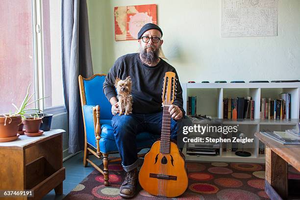 bearded man with small dog and mandolin - middle age man with dog stock-fotos und bilder