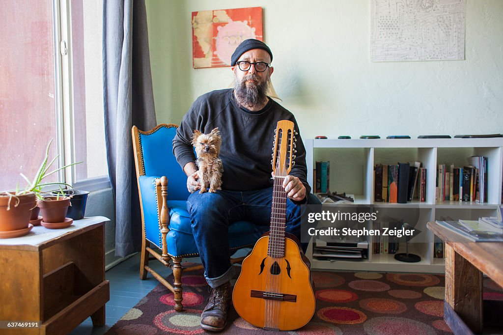 Bearded man with small dog and mandolin