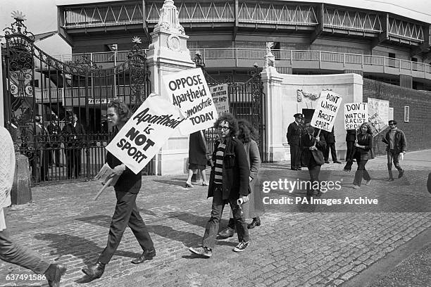 Supporters of the Anti-Apartheid 'Stop the Tour' movement parade with posters outside the Grace Gate at Lord's.