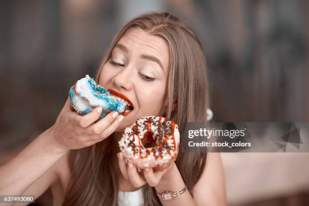 comer deliciosas rosquillas - antojo fotografías e imágenes de stock