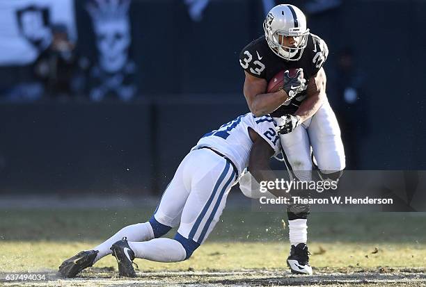 DeAndre Washington of the Oakland Raiders gets tackled by Vontae Davis of the Indianapolis Colts during the third quarter of their NFL football game...
