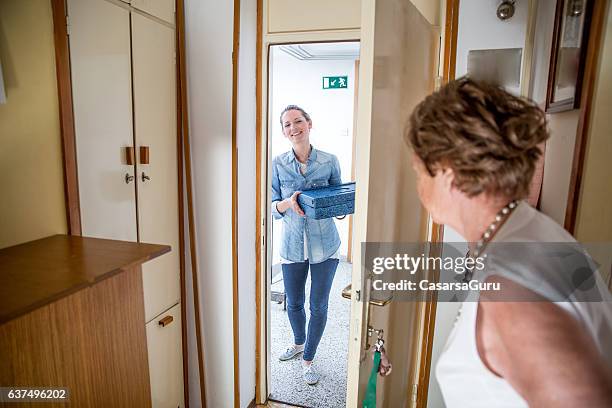 hot meal delivery to an elderly woman at home - meals on wheels stock pictures, royalty-free photos & images