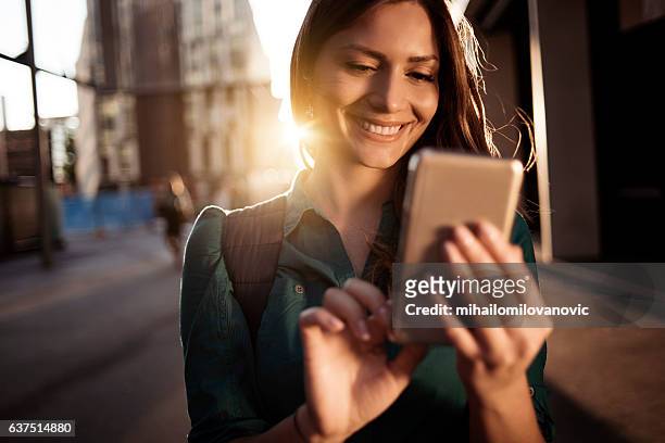 giovane donna felice che usa lo smartphone - donna sorride cellulare foto e immagini stock