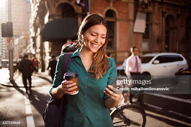 woman using smartphone in the city - coffee express stock pictures, royalty-free photos & images