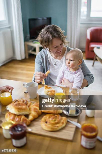 happy family with a child eating french breakfast at home - alexandra mora bildbanksfoton och bilder