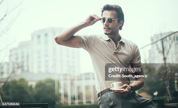drinking coffee in the city - polo shirt stock pictures, royalty-free photos & images