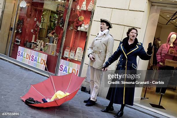 Two street artists in costumes singing in front of a shop window that indicates "sales" in Via Frattina on January 4, 2017 in Rome, Italy. The winter...