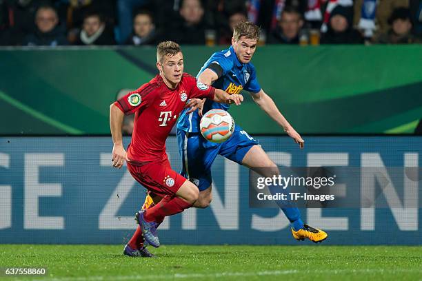 Joshua Kimmich of Bayern Muenchen and Simon Terodde of Bochum battle for the ball during the DFB Cup quarter final match between VfL Bochum and...
