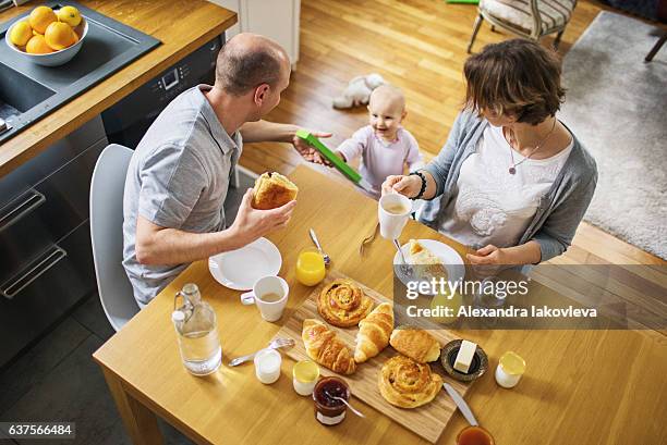 glückliche familie mit einem kind essen französisch frühstück zu hause - alexandra iakovleva stock-fotos und bilder