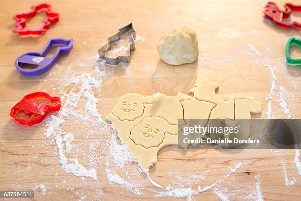 rolled out sugar cookies being cut into christmas shapes - danielle donders stock pictures, royalty-free photos & images