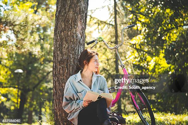 sala de estar en el bosque - mujer leyendo libro en el parque fotografías e imágenes de stock