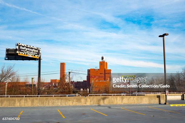 Budweiser beer factory viewed from across an empty parking lot, with a billboard for ParkingSpot, Newark, New Jersey, December 21, 2016. .