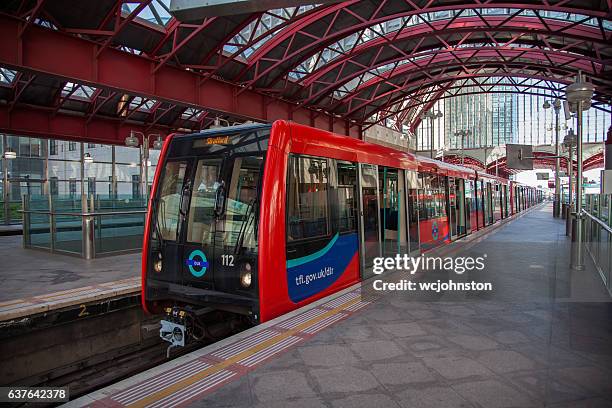 docklands light rail dlr train at canary wharf staion - docklands light railway stock pictures, royalty-free photos & images