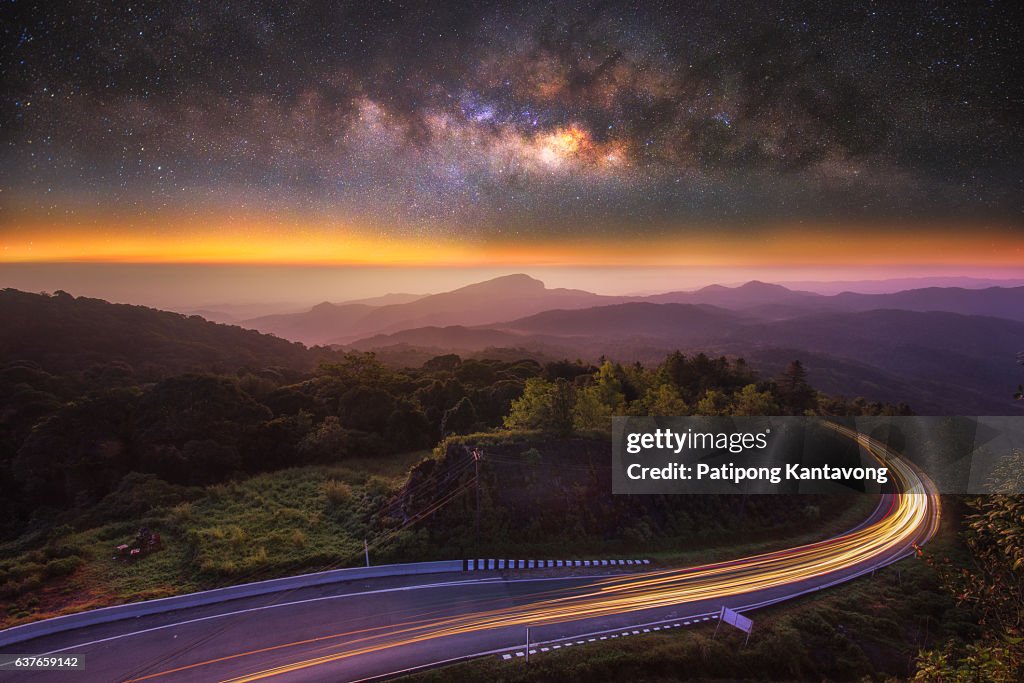 Milky way on the top mountain and road at front in intanon mountain , most tallest mountain in Chiangmai , Thailand