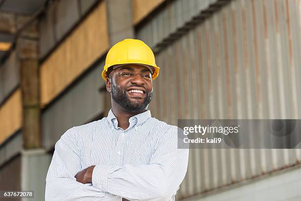 african american man wearing hard hat in warehouse - bygghjälm bildbanksfoton och bilder