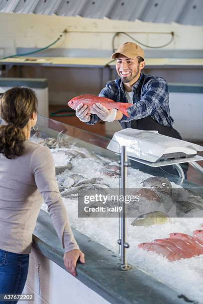 worker in seafood market helping customer - fish vendor bildbanksfoton och bilder
