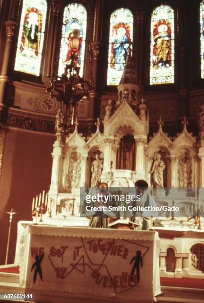 Pastor George H Clemens and alter boy praying in front of alter in Holy Angel Catholic Church, the largest black Catholic Church in Chicago,...