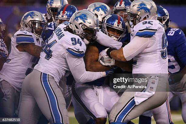 Defensive End Azekiel Ansah and Defensive Tackle Haloti Ngata of the Detroit Lions make a stop against the New York Giants during their game at...