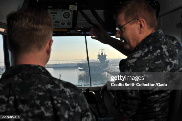 Captain Brian E Luther , commanding officer of aircraft carrier USS George HW Bush , and Captain Richard C McCormack , executive officer, watch...