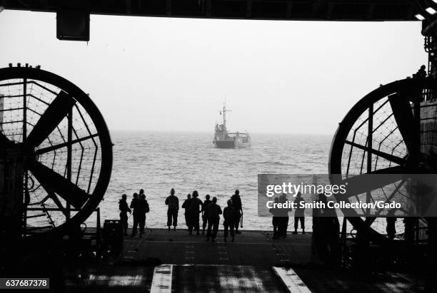 Sailors wait to perform a stern gate marriage with a utility landing craft in the well deck of the amphibious transport dock ship USS Green Bay,...