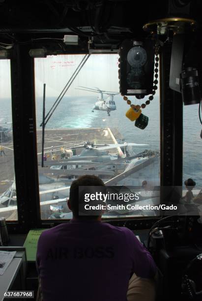Lieutenant Michael Landin oversees the takeoff of a helicopter from the flight deck control aboard the USS Green Bay, January 29, 2013. Image...