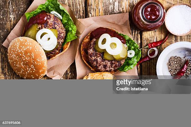 homemade burgers with meat cutlet and pickles - burger overhead stock-fotos und bilder