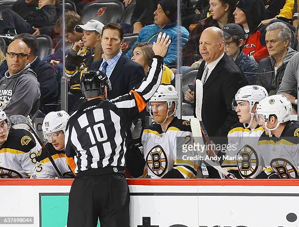 Head coach Claude Julien of the Boston Bruins talks to referee Kyle Rehman during the game against the New Jersey Devils at Prudential Center on...