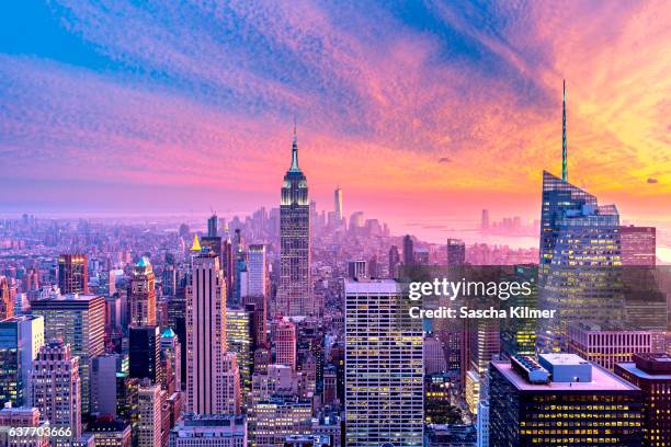 colorful sunset above new york city - rockefeller center stockfoto's en -beelden