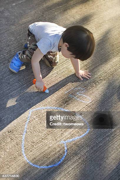 asian toddler boy drawing with chalk. - right cerebral hemisphere stockfoto's en -beelden