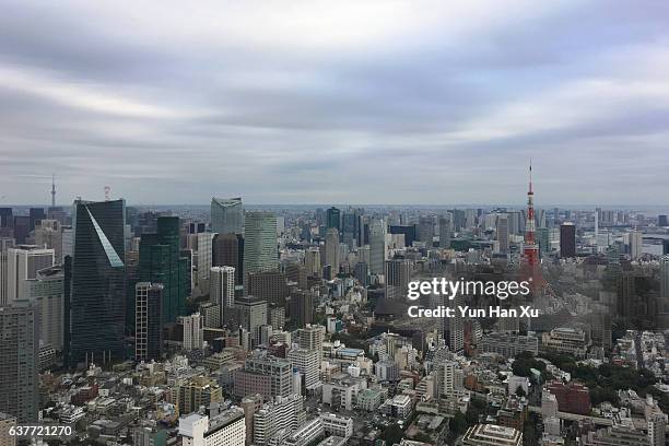 crowded downtown district of tokyo city against cloudy sky - cloudy day office building stockfoto's en -beelden