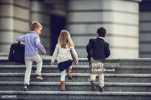 back view of business kids walking up the stairs. - carly simon signs copies of boys in the trees stockfoto's en -beelden