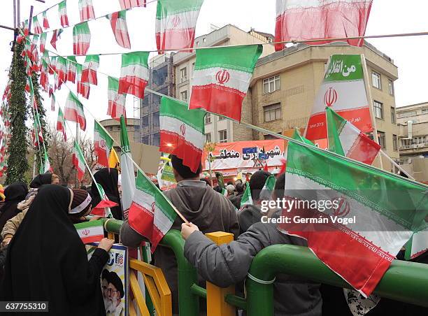 iranian flags and people march at islamic revolution anniversary rally, national day of iran - islamic revolution iran stock-fotos und bilder