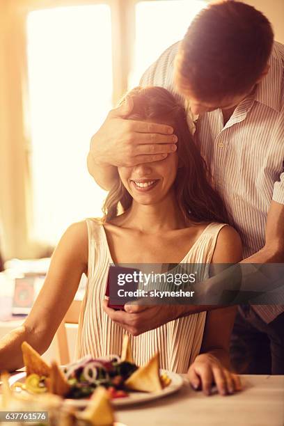 lächelnde frau wird von ihrem freund mit jewerly box überrascht. - man proposing indoor stock-fotos und bilder